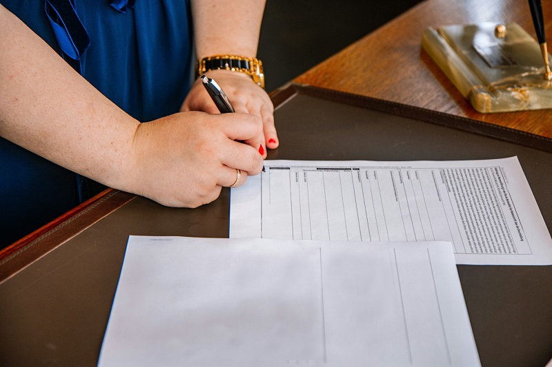 female signing paperwork